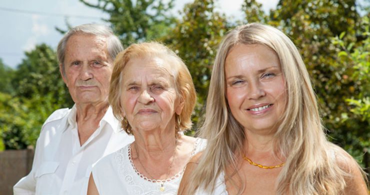 An older couple and a senior woman standing together.