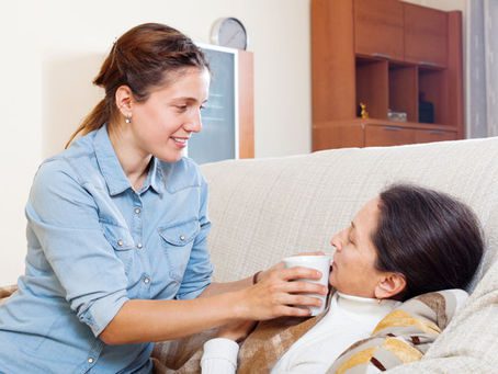 Woman sitting on couch, holding coffee cup.